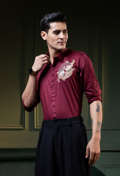 TWO FISH EMBROIDERED ON A MAROON SHIRT