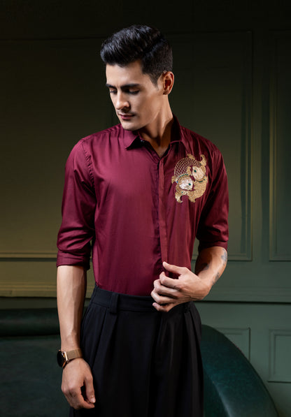 TWO FISH EMBROIDERED ON A MAROON SHIRT
