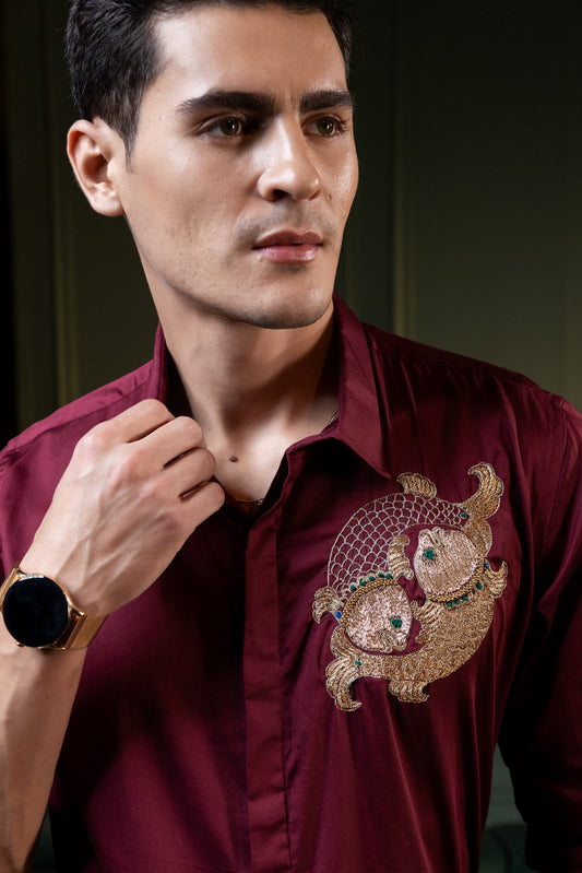 TWO FISH EMBROIDERED ON A MAROON SHIRT